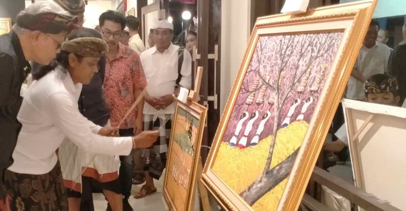 TUNJUKKAN TEKNIK MELUKIS Komang Bayu (baju putih, kedua dari kiri) tengah memperagakan Teknik melukisala pecut lidi,  saat pameran di Galeri I Gusti Gede Aryadi Art Space Tanah Lot Tabanan.  (foto: juliadi/radar bali)