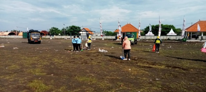 SAMPAH PESTA: Petugas dan warga menyapu areal lapangan sirkuit all in one di Jembrana hingga siang dan diangkut truk berkali-kali.