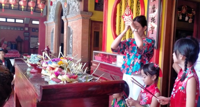 KHUSYUK: Umat keturunan Tionghoa Tabanan yang melaksanakan persembahyangan di tahun baru imlek dengan membakar kertas emas atau kimcua. (foto : juliadi/radar bali)