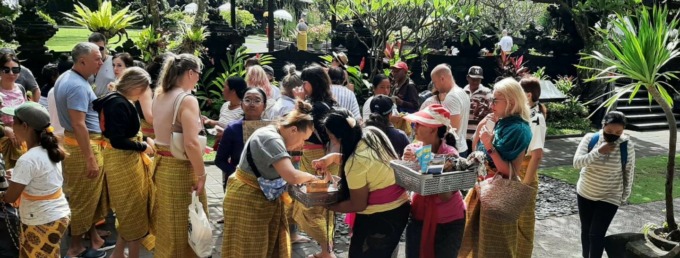 SEMPAT BERALIH PROFESI : Pedagang acung di Pura Goa Lawah saat menjajakan barang dagangannya kepada para wisatawan yang berkunjung (foto: dewa ayu pitri arisanti/radar bali)