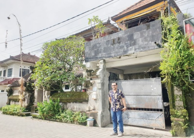 BERAWAL DARI SINI, 22 TAHUN LALU: Ida Bagus Pradnyan di depan rumahnya yang dulu adalah bangunan yang dipakai Jawa Pos Radar Bali berkantor di awal berdiri, selama dua tahun.(foto:ni kadek novi febriani/radar bali)