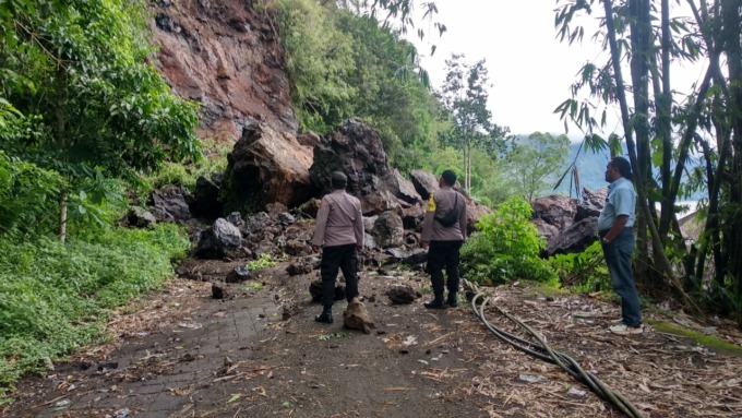 DAMPAK CUACA: Tanah fdan bebatuan yang longsor dari bukit menutup akses jalan di Songan Kintamani.