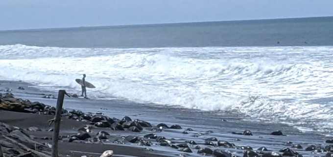 ASYIK BUAT SELANCAR : Seorang wisatawan tengah melihat kondisi ombak Pantai Batu Tumpeng sebelum berselancar. (foto: dewa ayu pitri arisanti/radar bali)