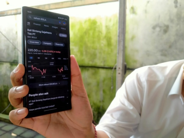 MELEMAH - Seorang pemain saham di pasar modal menujukkan neraca penurunan saham.