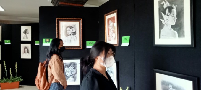 ART THERAPY: Dua mahasiswi Fakultas Kedokteran Universitas Udayana menikmati lukisan karya dr. Gede Bagus Darmayasa dalam pameran bertajuk “Atas Nama Cinta untuk Wanita”, Selasa (7/3/2023). (I KADEK SURYA KENCANA/RADAR BALI) 