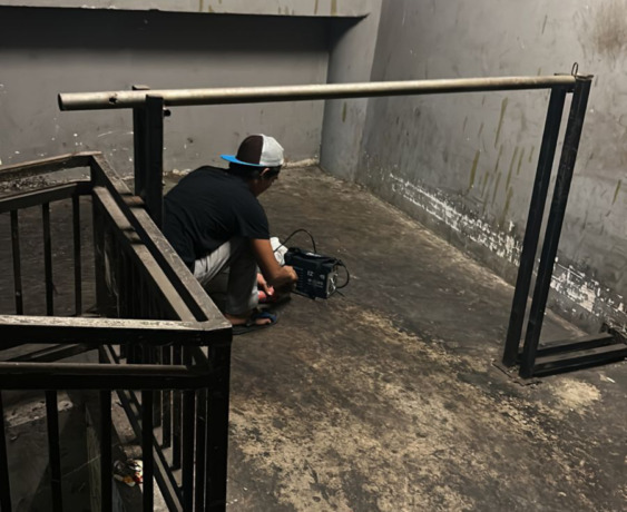 TAMPARAN: Tukang sedang melakukan pengelasan palang portal agar sepeda motor tak naik ke lantai atas Pasar Badung. Foto: Adrian Suwanto/Radar Bali