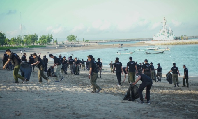 PEDULI LINGKUNGAN: Anggota Satpol PP Kabupaten Badung saat melakukan aksi bersih-bersih pantai dalam merayakan HUT ke-73 korps penegak Perda ini (16/3/2023)