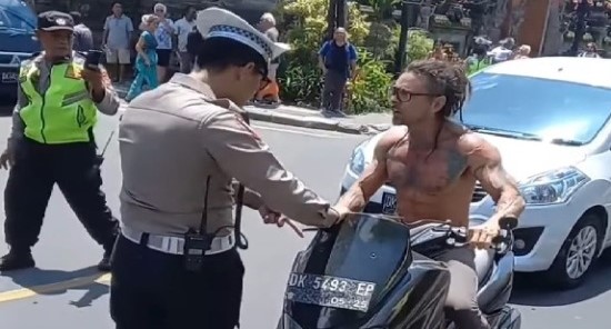 SUDAH MELANGGAR, NGEYEL PULA: Wisatawan bule tanpa helm, tanpa baju, ngeyel ke polisi saat hendak ditilang  di Catus Pata Puri Ubud, Gianyar, beberapa waktu lalu.  (foto:istimewa)