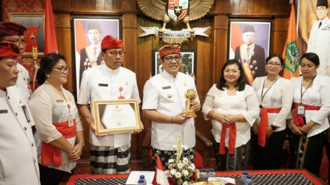 RAIH PENGHARGAAN: Bupati Tabanan Bupati Tabanan, Dr. I Komang Gede Sanjaya,S.E.,M.M, saat menerima penghargaan UHC Award 2023 di kantor Bupati Tabanan, pada Kamis (16/3/2023).