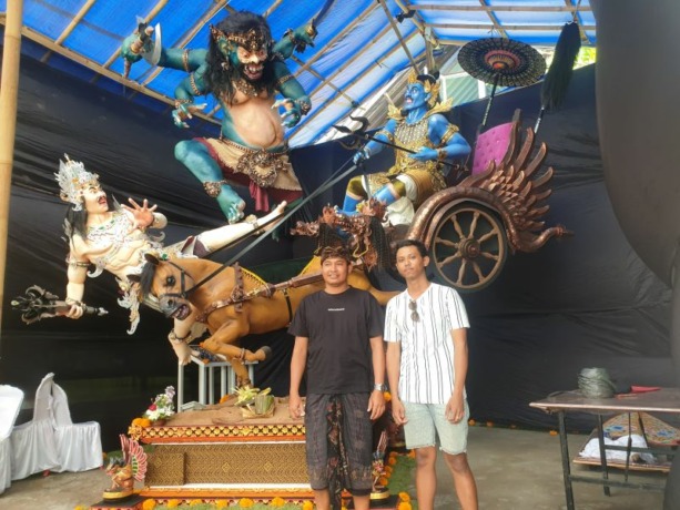 MEREBUT TAHTA: Konseptor Ogoh-ogoh ST. Eka Bhuana Tunggal Budi Banjar Adat Seminyak Kaja (kiri) bersama Keliat Banjar Adat Seminyak Kaja, I Gusti Agung Made Dwiana Utama bersama ogoh-ogoh Rabasa Warasana Ing Triloka, di  Seminyak, kemarin (8/3). Foto: Ni