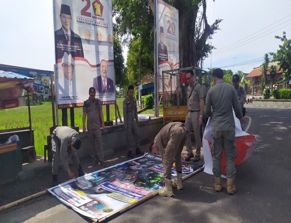 Petugas Satpol PP Jembrana saat menertibkan baliho dan spanduk di Jalan Denpasar – Gilimanuk. (FOTO M. BASIR/RADAR BALI)