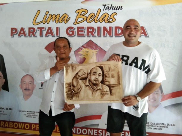 DUKUNG KREATIVITAS: Seniman asal Kota Singaraja, Buleleng, Putu Arimbawa (kiri) menyerahkan hasil karya lukisan kopi ke Ketua DPD Partai Gerindra Bali, Made Muliawan Arya di kantor DPD Partai Gerindra Bali, Senin (3/4/2023). (Partai Gerindra untuk Radar B