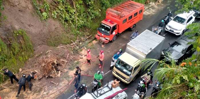 TERGERUS AIR : Kondisi tanah longsor dan pohon tumbang di Jalan Gatot Subroto masuk Banjar Sanggulan, Desa Banjar Anyar, Kediri, Tabanan (foto:juliadi/radar bali).