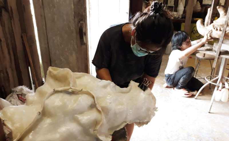 TUNTASKAN KARYA : Nancy Ng, salah seorang perupa sedang menuntaskan karyanya pameran. (foto:istimewa)