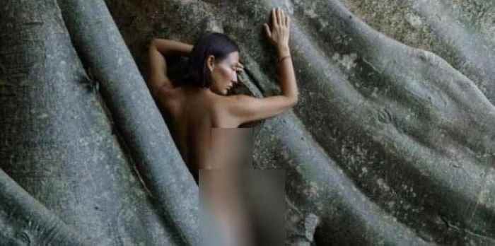 BERFOTO TELANJANG: Seorang warga asing perempuan berpose tanpa busana di pohon kayu putih raksasa, Desa Tua, Marga, Tabanan.(foto:istimewa)