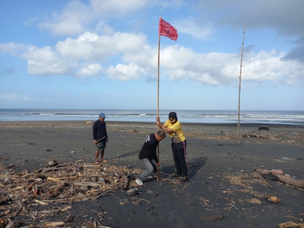 Polsek Kerambitan Tabanan dan warga setempat yang memasang bendera tanda larangan di Pantai Kelating, Desa Kelating, Kerambitan. (ist)