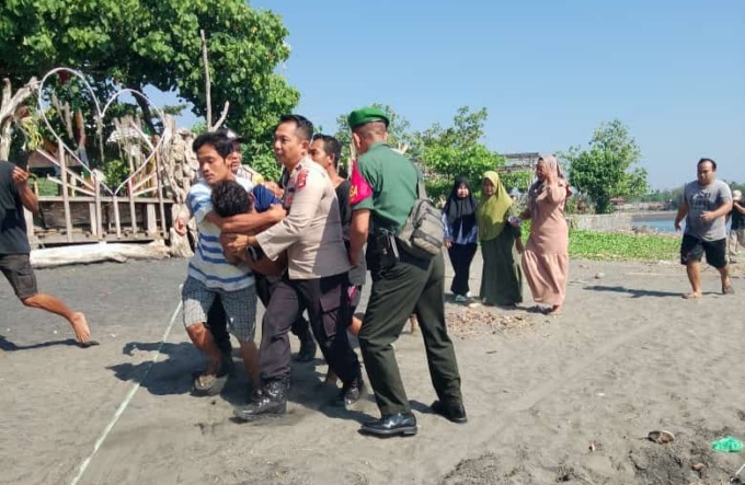 CELAKA: Proses evakuasi Husie, nelayan yang perahunya terbalik dan tenggelam diterjang ombak di muara sungai Perancak