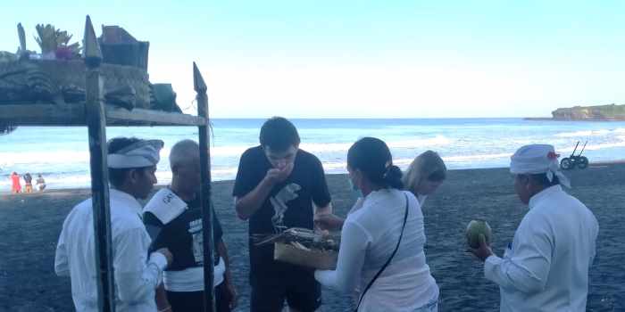 BERSIAP IKUT PROSESI RITUAL : Suasana warga dan WNA asal Jerman Roben dan Paulina mengikuti prosesi ritual Banyupinarih di Pantai Klecung Desa Tegal Mengkeb, Selemadeg Timur, Tabanan.(foto:juliadi/radarbali)