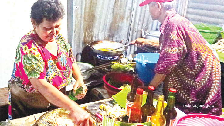 KULINER MALAM: Mbak Sri tampak cekatan menyajikan lontong tahu. Berada di Kawasan Pecinan Banjarejo, aromanya terus melegenda. (EKA FITRIA MELLIANA/RDR.BJN)