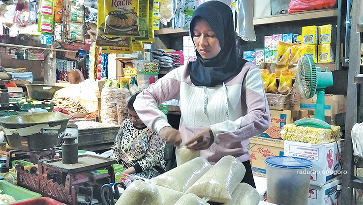 KOMODITAS: Salah satu pedagang gula pasir di Pasar Tradisional Bojonegoro Kota. Gula kian naik mendekati HET atau harga eceran tertinggi. (YANA DWI KURNIYA WATI/RDR.BJN)