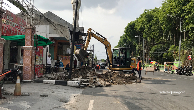 DIKERUK: Pekeja menggerakkan ekskavator membongkar drainase lama di Jalan KH Hasyim Asyari, Senin (3/7). (BHAGAS DANI PURWOKO/RDR.BJN)