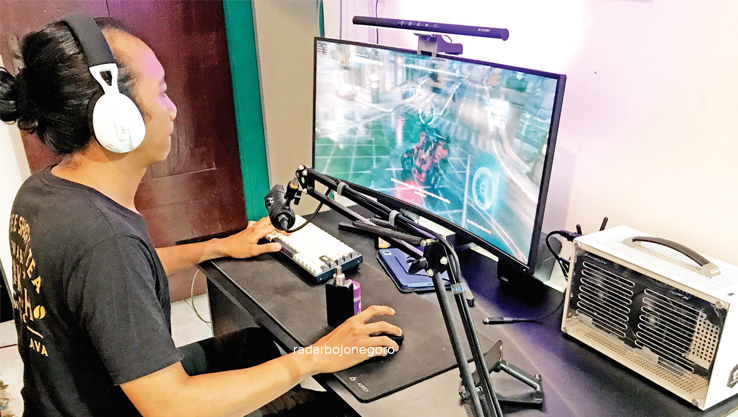 UTAK-ATIK KOMPUTER: Evans Rimbawan menunjukkan salah satu PC yang dirakit untuk bermain game. (BHAGAS DANI PURWOKO/RDR.BJN)