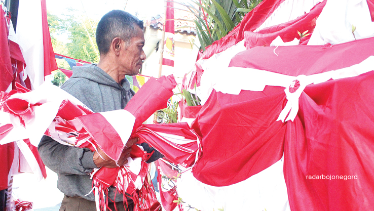 MOMEN TAHUNAN: M Sulaiman, pedagang bendera asal Garut, Jawa Barat, yang setiap tahun ke Lamongan untuk berjualan bendera merah putih dan pernak pernik Agustusan. (AHMAS ASIP ALAFI/RDR.LMG)