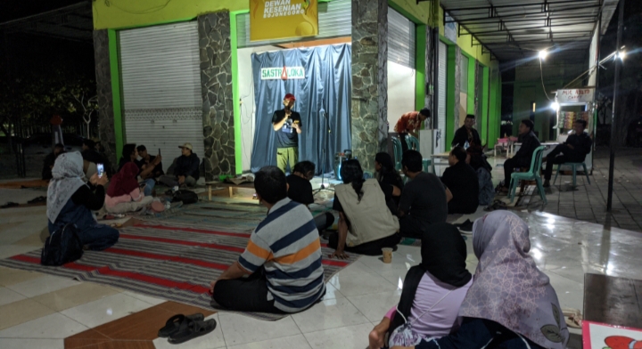 BERPUISI: Pegiat sastra membacakan sajak saat panggung puisi di salah satu warung kopi di Taman Rajekwesi Bojonegoro, Jumat (21/7) malam. (WAHYU DHANI A/RDR.BJN)