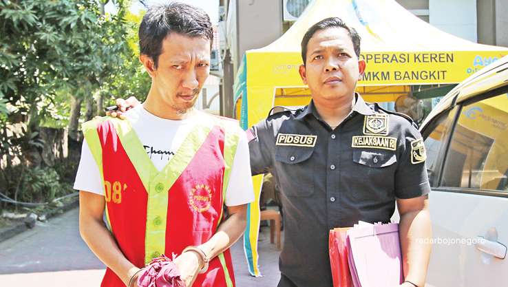 DIGELANDANG PETUGAS: Tersangka pengedar rokok tanpa cukai, Ya&rsquo;qub, 37, saat berada di Kantor Kejari Lamongan dan dibawa menuju Lapas Kelas II B Lamongan. (ANJAR DWI PRADIPTA/RDR.LMG)