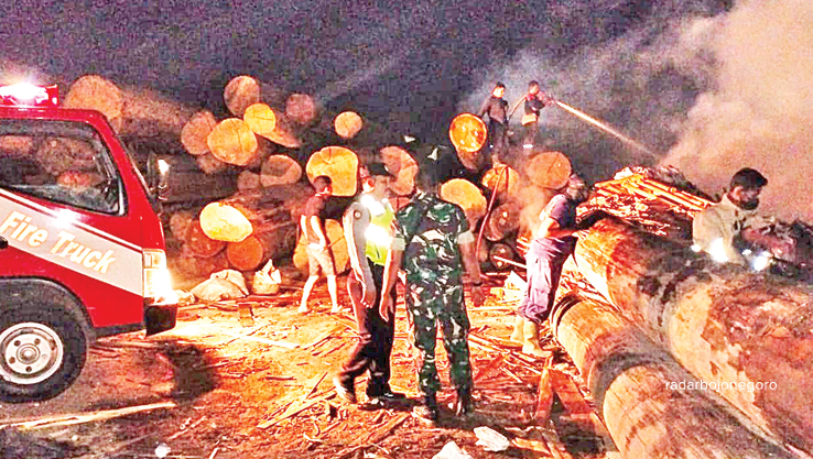 KEMBALI TERBAKAR: Petugas berupaya memadamkan kobaran api yang membakar tumpukan kayu di PT Tanahmas Kencana Abadi (TKA) di Desa Kalen, Kecamatan Kedungpring. &nbsp;(ISTIMEWA FOR RDR.LMG)