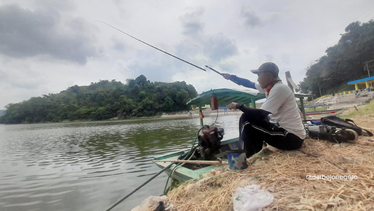 WADUK PACAL: Indahnya pemandangan di bantaran Waduk Pacal memanjakan penglihatan. Pemancing asal Nganjuk menikmati keindahan sambil memancing. (AHMAD HAKAM ALGHIVARI/RDR.BJN)