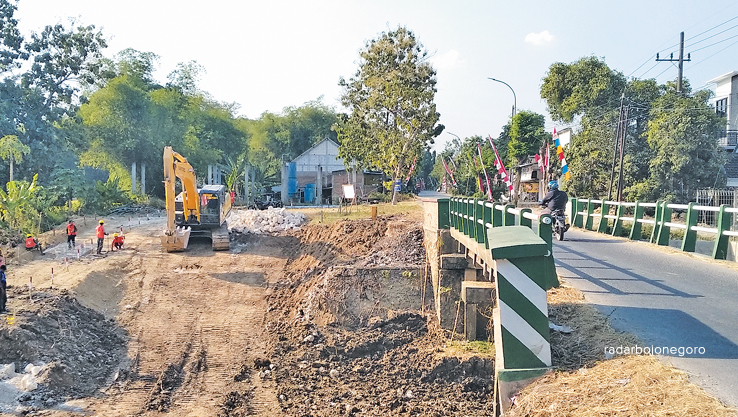 PENGERUKAN: Jembatan Kapas-Glendeng akan dilebarkan. Alat berat mulai diturunkan mengeruk tanah sekitar jembatan. (YANA DWI KURNIYA WATI/RDR.BJN)