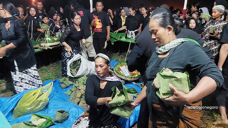 SEGO BERKAT: Warga Samin membagikan nasi berkat dibungkus daun jati saat agenda peringatan perjuangan Samin Surosentiko di Ploso Kediren Randublatung. (LUKMAN HAKIM/RDR.BLORA)