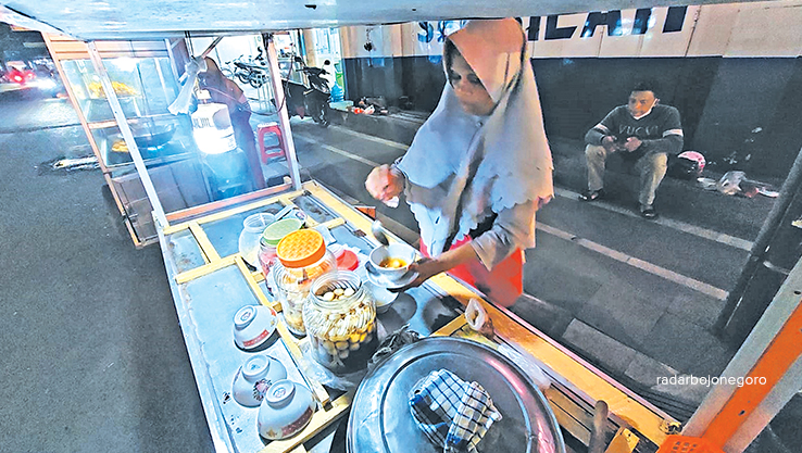 MENGHANGATKAN: Rukmini dengan cekatan menyiapkan satu mangkuk wedang ronde kepada pelanggan. Kudapan ini cocok untuk menghangatkan tubuh saat malam. (LUKMAN HAKIM/RDR.BLORA)