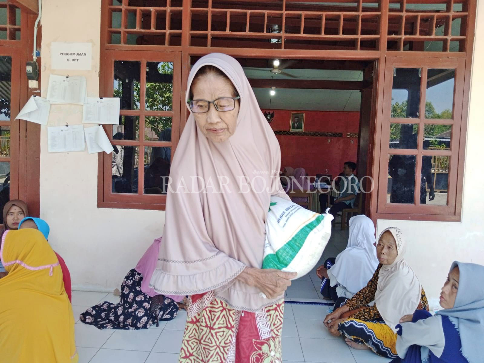 BANTUAN: Pemkab Blora salurkan beras kepada 89.330 KPM. Seorang ibu di Desa Purwosari itu peroleh bantuan beras 10 kilogram. (RAHUL OSCARRA DUTA/RDR.BJN)
