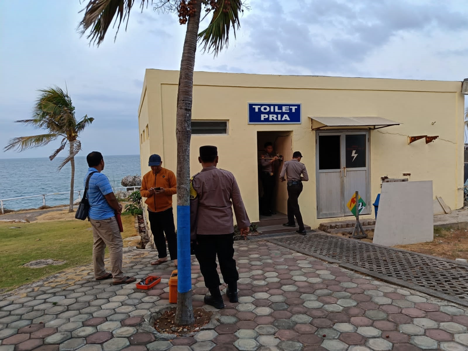 LAKUKAN PEMERIKSAAN: Petugas kepolisian melakukan pemeriksaan di toilet tempat salah satu pengunjung meninggal dunia bersandar di tembok. (IST/RDR.BJN)