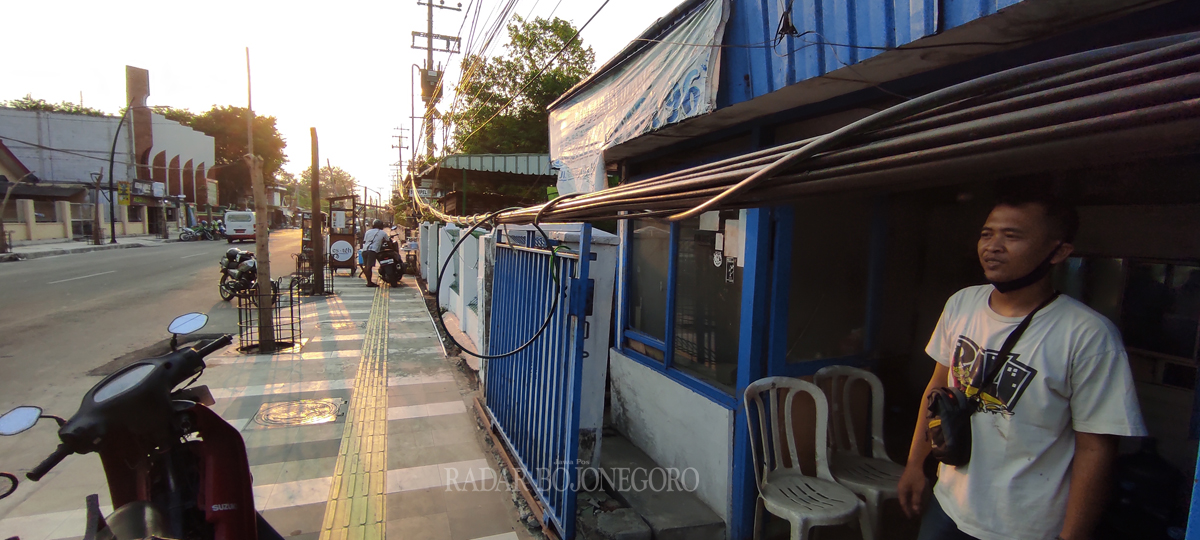 MENGGANGGU : Sebuah kabel menjuntai di Jalan Pemuda Bojonegoro mengganggu aktivitas warga. Bahkan, membahayakan.(DHANI WAHYU ALFIANSYAH/RDR.BJN)