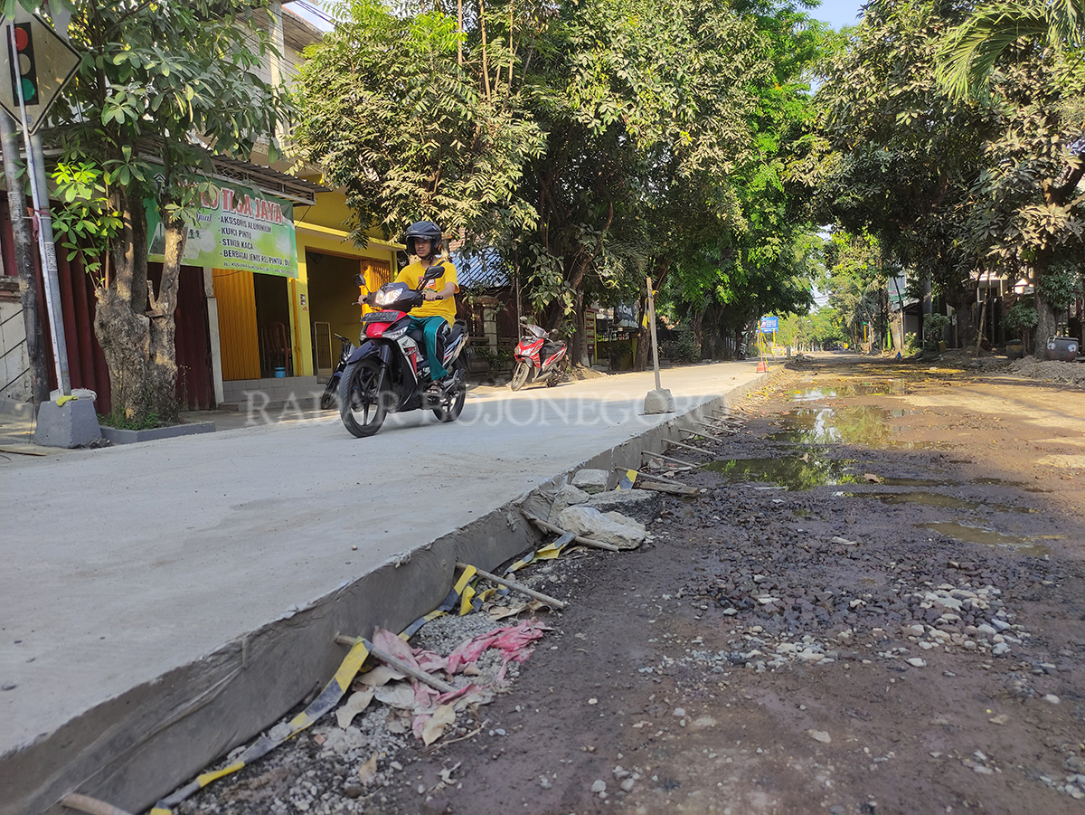 RESAH: Warga di pinggir Jalan Kusuma Bangsa khawatir peninggian jalan yang tidak dibarengi perbaikan drainase, nantinya bakal memperparah banjir saat musim hujan. (ANJAR DWI PRADIPTA/RDR.LMG)