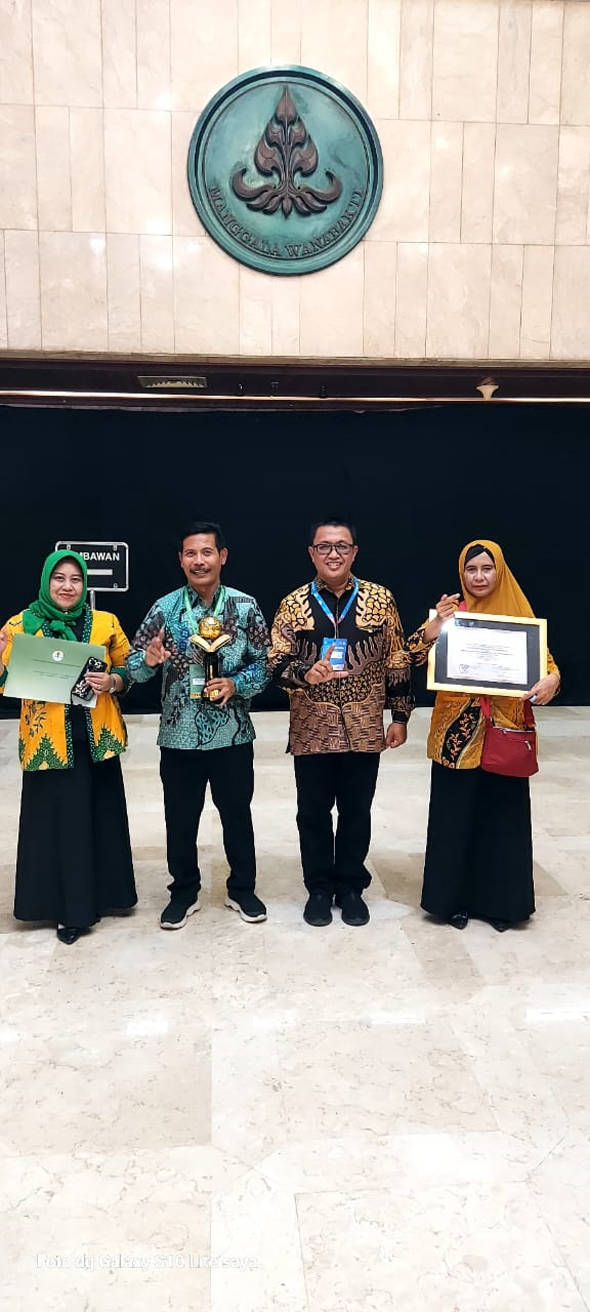 PEDULI LINGKUNGAN: Kepala Dinas Lingkungan Hidup (DLH) Pemkab Lamongan Andy Kurniawan dan Kepala SMP Negeri 1 Mantup Safiuddin usai menerima penghargaan Adiwiyata Mandiri. (ISR/RDR.LMG)