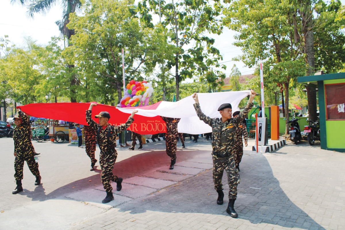 SEMANGAT : Bendera merah putih diarak dan dibentangkan oleh petugas pada acara peringatan HSN di Kabupaten Blora Minggu (22/10)(LUKMANHAKIM/RDR.BLORA)
