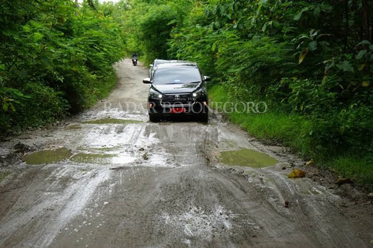RUSAK: Mobil dinas Pemkab Blora melewati ruas jalan Randublatung-Getas yang rusak parah. Tahun ini pengajuan pembangunan ruas jalan itu telah disetujui Pemerintah Pusat. (LUKMAN HAKIM/RDR.BJN)