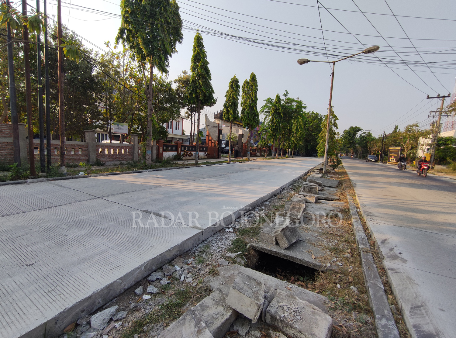 DIUSULKAN TAHUN DEPAN: Saluran pembuangan air yang terlihat belum tertata di antara dua jalan yang sudah dicor di belakang Terminal Lamongan. (ANJAR DWI PRADIPTA/RDR.LMG)