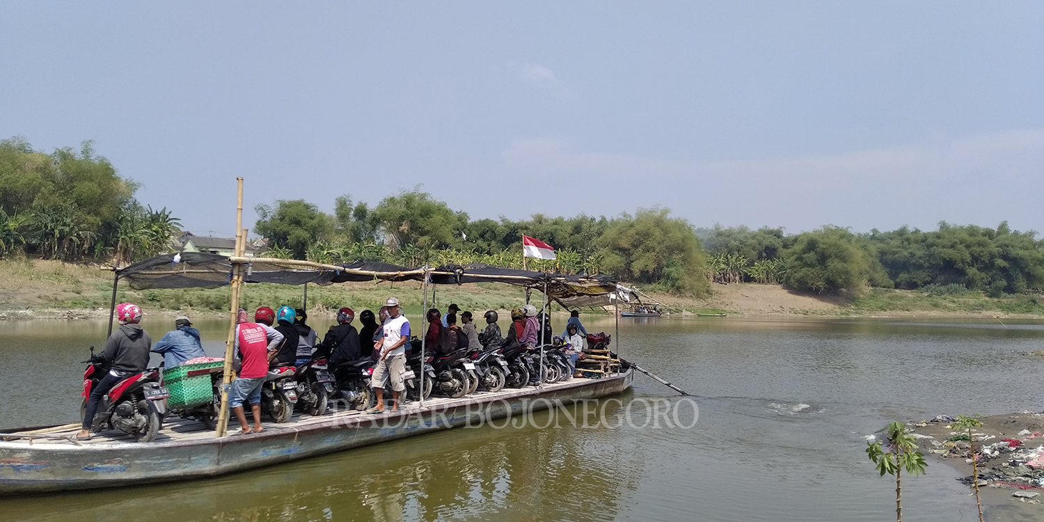 TAMBANGAN: Tampak pengunjung menaiki perahu tambangan dari sisi Selatan sungai Bengawan Solo sekitar Jembatan Glendeng. (YANA DWI K/RDR.BJN)