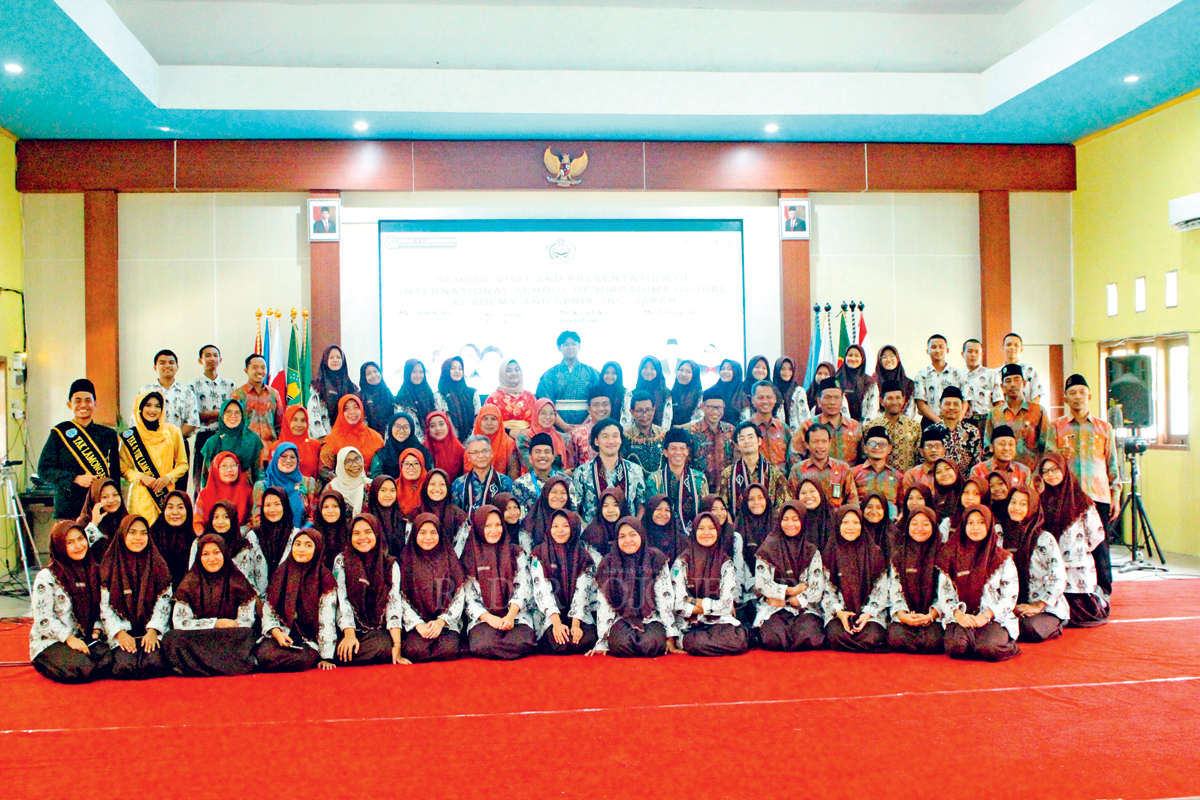 KEBERSAMAAN: Kepala MAN 1 Lamongan, Nur Endah Mahmudah beserta siswa-siswi MAN 1 Lamongan foto bersama dengan tamu kunjungan dari Jepang.(GAMAL AYATULLAH/RDR.LMG)