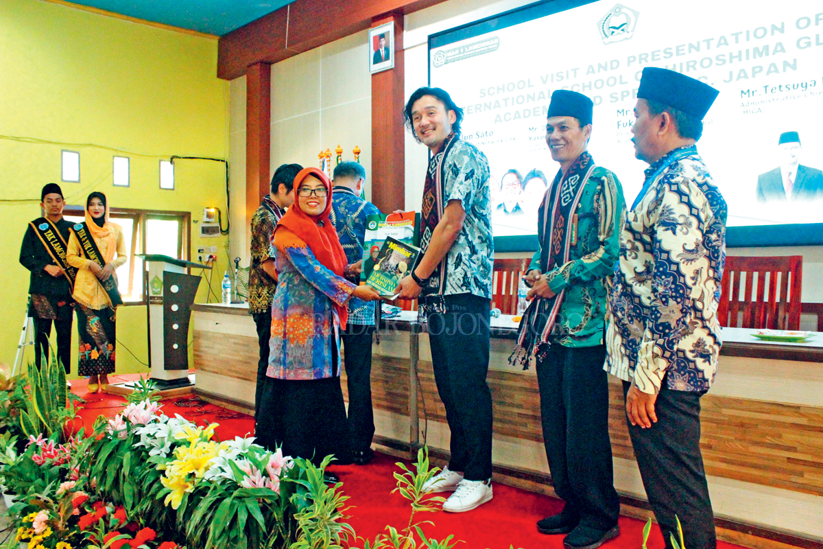 CENDERAMATA: Kepala Sekolah MAN 1 Lamongan, Nur Endah Mahmudah memberikan souvenir kepada salah satu tamu kunjungan dari Jepang.(GAMAL AYATULLAH/RDR.LMG)