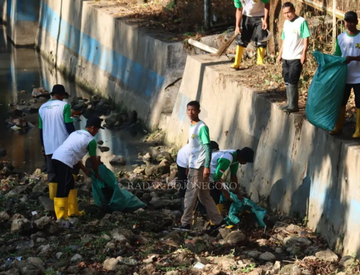 TERCEMAR: Petugas DLH dan DPUPR Blora lakukan pembersihan Kali Grojogan yang tercemar limbah rumah tangga. (LUKMAN HAKIM/RADAR BLORA)