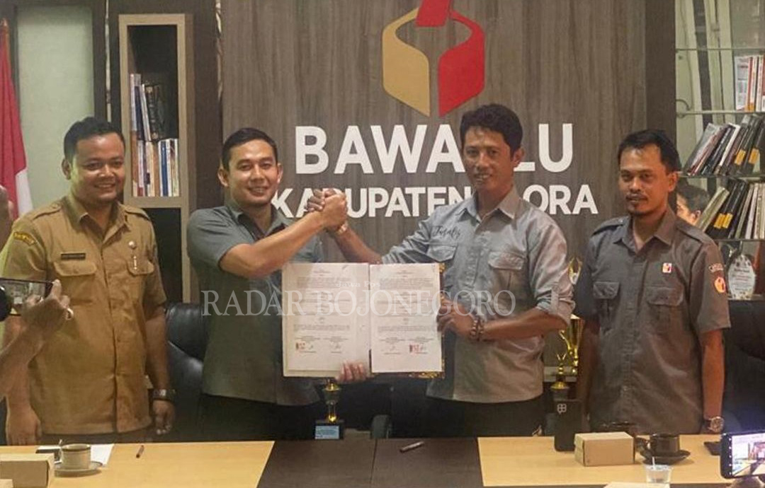 TANGKAL: Ketua Bawaslu Blora Andyka Fuad Ibrahim (kiri) berjabat tangan dengan Ketua PWI Blora Heri Purnomo guna bekerja sama dalam upaya menangkal berita hoaks jelang pemilu 2024.