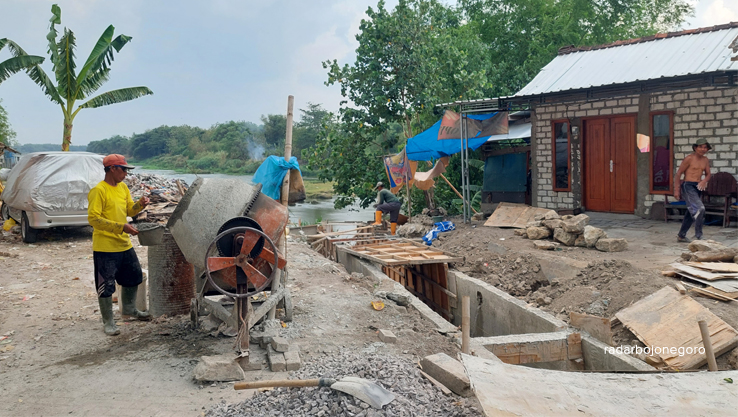 PROYEK: Para pekerja sedang menyelesaikan proyek drainase yang berada di atas bibir Bengawan Solo. (LUKMAN HAKIM/RADAR BLORA)