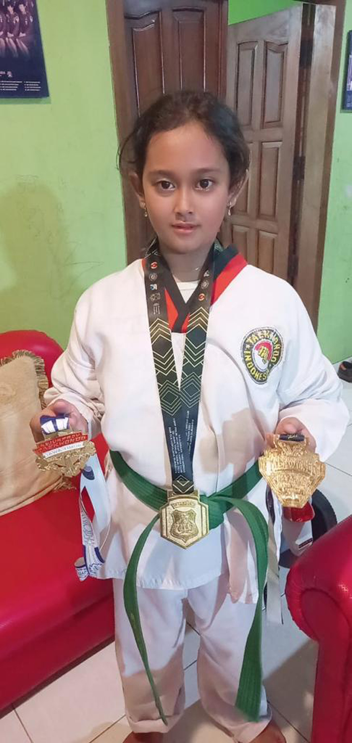 KOMITMEN: Alia Maryam Gadafi, atlet taekwondo cilik asal Kelurahan Ledok Wetan pamerkan perolehan medali emas tingkat Provinsi Jawa Timur. (ALIA FOR RADAR BOJONEGORO)