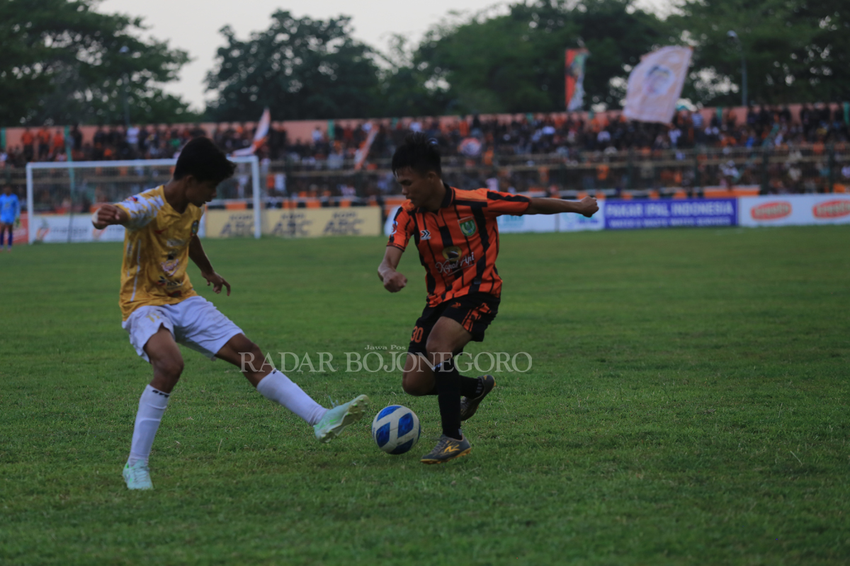 LOLOS: Jo Sianturi winger Persibo mencoba melewati pemain Persatu pada pertandingan di SLS Minggu (17/12). Laga terakhir grup N tersebut berakhir imbang dengan skor 0-0. (YUAN EDO/RADAR BOJONEGORO)